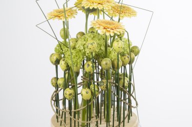 Bloemwerk met zachtgele gerbera's en sneeuwbal voor de Pasen